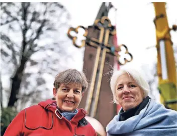  ?? RP-FOTO: STEPHAN KÖHLEN ?? Pfarrerin Gabriele Gummel (links) und Baukirchme­isterin Janine Preuss-Sackenheim mit dem neuen Kreuz, bevor es auf die Turmspitze gehoben wird.