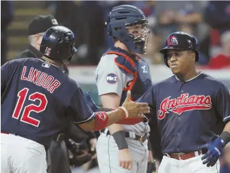  ?? AP PHOTO ?? HOT STUFF: Jose Ramirez gets a hand from Francisco Lindor after hitting a two-run homer as the Indians cruised to their 19th straight victory last night.