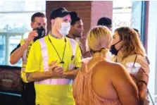  ?? ANDREW NELLES/THE TENNESSEAN ?? Dr. Michael Caldwell, director of Nashville’s Metro Public Health Department, reminds people to wear masks on Lower Broadway in Nashville on Friday.