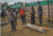  ?? Dar Yasin / Associated Press ?? The wife of a Rohingya man who died while fleeing to Bangladesh gets help transporti­ng his body.