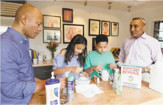  ?? Photos by Peter Prato / Special to The Chronicle ?? Ken McNeely, president of AT&T California, and his husband, Dr. Inder Dhillon, are guided by their kids, Meera and Kabir, in making slime at their S.F. home.
