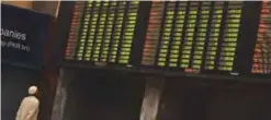  ?? —AFP ?? KARACHI: A Pakistani stockbroke­r watches an index board showing share prices during a trading session at the Pakistan Stock Exchange (PSX) in Karachi yesterday. The benchmark PSX-100 index was up 729.43 points to 52102.94 at mid-day trade.