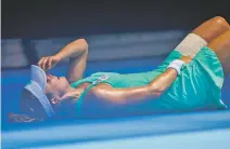  ?? ANDY BROWNBILL/THE ASSOCIATED PRESS ?? France’s Alize Cornet falls to the court Friday after suffering from the heat during her third round match against Belgium’s Elise Mertens at the Australian Open in Melbourne, Australia.