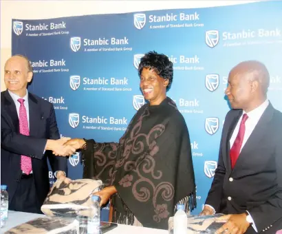  ??  ?? Stanbic bank chairman Greg Sebborn (left) hands over blankets to Harare Hospital chief executive Peggy Zvavamve while chief executive Joshua Tapambgwa (right) follows proceeding­s during a handover ceremony in Harare last week. (Picture by Tariro...