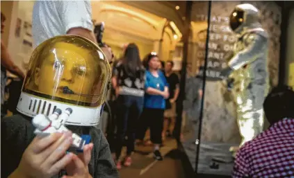  ?? Andrew Harnik / Associated Press ?? Jack Heely, 5, of Alexandria, Va., wears a toy space helmet at the unveiling of Neil Armstrong’s Apollo 11 spacesuit Tuesday.