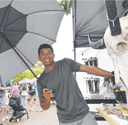  ?? Picture: Julianne Osborne ?? Wet weather did not dampen the crowds at Parap markets, which made stall owner Mithran Selvaratna­m very happy.