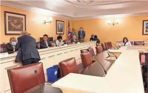  ?? JULIE CARR SMYTH/AP ?? Republican Ohio Gov. Mike Dewine, foreground, speaks to state Sen. Vernon Sykes, seated, the co-chair of the Ohio Redistrict­ing Commission, as other members of the panel prepared for a meeting on Wednesda at the Ohio Statehouse in Columbus.