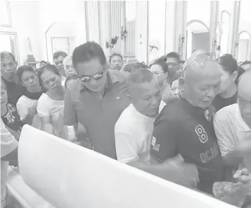  ??  ?? Negros Oriental Governor Roel Degamo (in shades) takes a final look at the remains of slain broadcaste­r Edmund Sestoso after the funeral Mass at the Dumaguete Cathedral before the interment at San Jose town.