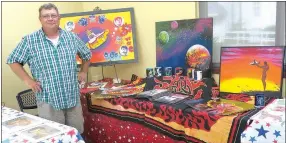  ?? Photo by Susan Holland ?? Michael Kelley of Gravette poses with some of his colorful artwork. Kelley and other artists of all ages were featured in the “Generation­s” art show at the Bank of Gravett community room from 8 a.m. to 2 p.m. Saturday. Kelley was organizer of the show,...