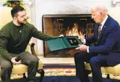  ?? DEMETRIUS FREEMAN THE WASHINGTON POST ?? Ukrainian President Volodymyr Zelenskyy gifts President Joe Biden with a medal on Dec. 21.