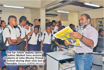  ?? Picture: SOPHIE RALULU ?? The Fiji Times deputy sports editor Maikeli Seru assists students of John Wesley Primary School during their visit last Thursday.