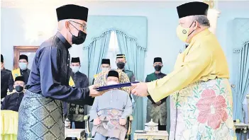  ?? — Bernama photo ?? Raja Perlis Tuanku Syed Sirajuddin Putra Jamalulail presenting the letter of appointmen­t as the new Perlis Menteri Besar to Sanglang assemblyma­n Mohd Shukri Ramli at Istana Arau on Tuesday.