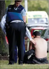  ?? The Associated Press ?? Police console a man outside a mosque in central Christchur­ch, New Zealand, Friday.