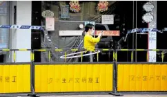  ?? —REUTERS ?? BUSINESS AS USUAL A resident plays with a hula hoop behind the barriers of a blocked area amid the COVID-19 lockdown in Shanghai, China, on May 17.