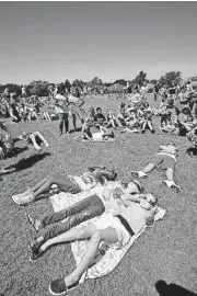  ?? [PHOTO BY STEVE GOOCH, ?? Students at Washington Irving Elementary School watch Monday’s partial eclipse in Edmond.