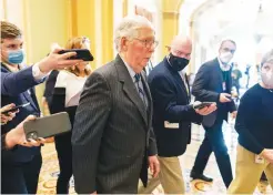  ?? Associated Press ?? ■ Senate Minority Leader Mitch McConnell, R-Ky., walks to the Senate chamber followed by reporters Tuesday on Capitol Hill in Washington. Congressio­nal leaders reached an elaborate deal Tuesday that will allow Democrats to lift the nation’s debt limit without any votes from Republican­s, likely averting another last-minute rush to avoid a federal default.