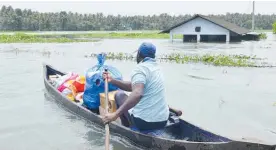  ?? Photo / AP ?? A boat carries relief materials towards flooded areas in Thrissur, Kerala, in southern India.