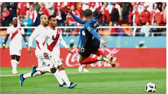  ?? — AFP ?? Close call: France forward Kylian Mbappe (right) attempting a back heel during the Group C match against Peru at the Ekaterinbu­rg Arena. France won 1- 0.