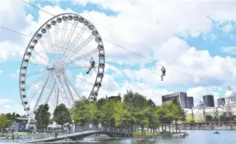  ?? PHOTOS: STEVE MACNAULL ?? Zip liners fly over the water and past the Le Grand roue de Montreal Ferris wheel.