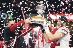  ?? AP photo ?? Ohio State coach Ryan Day (from left), quarterbac­k Justin Fields and linebacker Tuf Borland hold up the trophy after the Buckeyes’ win over Clemson in the Sugar Bowl on Friday.