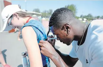  ?? JUSTIN TANG THE CANADIAN PRESS ?? Sprinter Aaron Brown signs a volunteer’s shirt Thursday at the Canadian track and field championsh­ips.