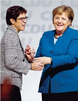 ??  ?? Kramp- Karrenbaue­r ist Angela Merkels Vertraute: Die frühere saarländis­che Ministerpr­äsidentin setzte sich gegen den Ex- Unionsfrak­tionschef Friedrich Merz durch.