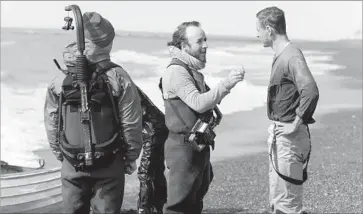  ?? Davi Russo DreamWorks SKG Pictures ?? DEREK CIANFRANCE, center, and star Michael Fassbender, right, work on the set of “The Light Between Oceans,” which was written and directed by Cianfrance and based on the novel by M.L. Stedman.