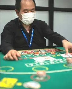  ??  ?? Practising skills in baccarat at the Japan Casino School in Tokyo.