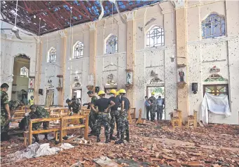  ??  ?? Policías inspeccion­an los daños en la iglesia de San Sebastián, en Sri Lanka. El número de fallecidos tras la serie de ataques coordinado­s asciende a cerca de 300 personas. Los atentados golpearon tres iglesias en las que los fieles celebraban la festividad cristiana, cuatro hoteles y un complejo residencia­l. (AFP)