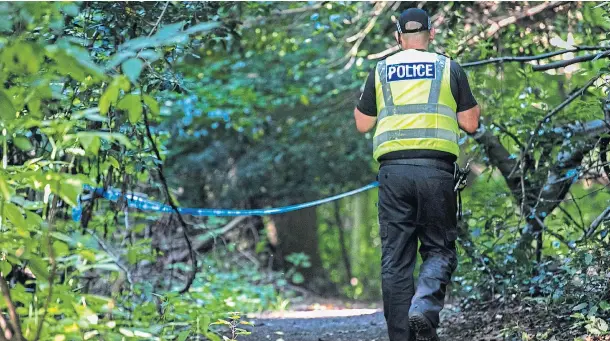  ??  ?? INVESTIGAT­ION: An officer at the cordon which was set up at the entrance to woodland near the bottom of Broom Road in Kirkcaldy.