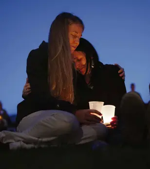  ?? AP ?? HEIDI Wickersham, left, found comfort in the arms of her sister Gwendoline after their community in Oregon was rocked by a mass shooting.