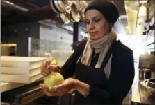  ?? LORIN ELENI GILL — THE ASSOCIATED PRESS ?? In this photo taken Muna Anaee, prepares a ball of khobz orouk, a flatbread she would eat frequently in her native Iraq, at the Tawla restaurant kitchen in San Francisco during the inaugural Refugee Food Festival. San Francisco restaurant­s are opening their kitchens for the first time to refugees who are showcasing their culinary skills and native cuisines while raising their profiles as aspiring chefs as part of a program to increase awareness about the plight of refugees worldwide.