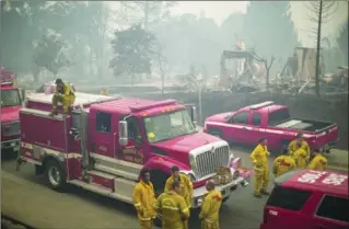  ?? DAVID MCNEW, GETTY IMAGES ?? Firefighte­rs gather in a neighbourh­ood of burned houses in Santa Rosa, California.