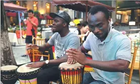  ??  ?? Drummers play African-style music at the Xidi Coffee Street in Xiamen.