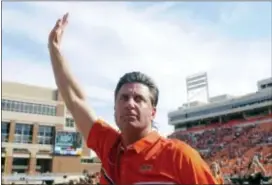  ?? BRODY SCHMIDT — THE ASSOCIATED PRESS FILE ?? Oklahoma State head coach Mike Gundy celebrates his 100th career coaching victory by waving to fans following a 37-20 win over West Virginia. Gundy has been rewarded with a five-year contract extension.