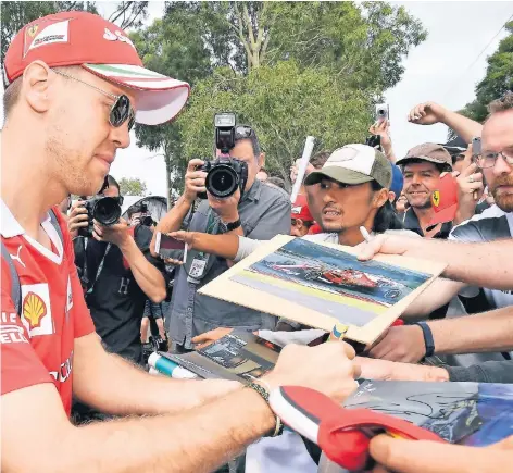  ?? FOTO: DPA ?? Gefragt als Autogramms­chreiber: Der viermalige Weltmeiste­r Sebastian Vettel.