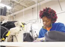  ?? KIM HAIRSTON/BALTIMORE SUN ?? Anifa Sanza, who fled the Democratic Republic of Congo with two children, sews uniforms at Blind Industries and Services of Maryland.