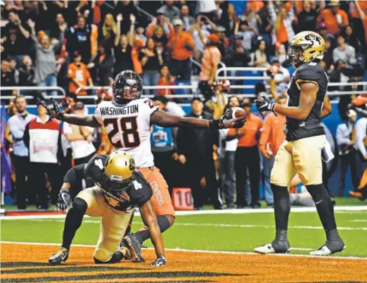  ?? Andy Cross, The Denver Post ?? Oklahoma State’s James Washington celebrates Thursday after scoring against CU’s Chidobe Awuzie, left, and Tedric Thompson.