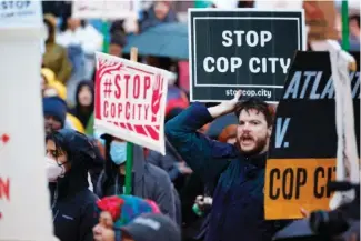  ?? AP PHOTO/ALEX SLITZ ?? Protesters hold signs and chant slogans during a March 9 protest against plans to build a new police training center in Atlanta.