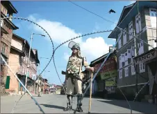  ??  ?? An Indian paramilita­ry soldier stands guard near a checkpoint during a curfew in Srinagar, Kashmir, last month