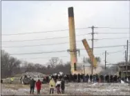  ??  ?? Above and below right, two smokestack­s from the former Sonoco paper mill plant in Downingtow­n fell to the ground as local residents watched.