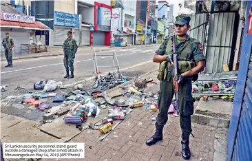 ??  ?? Sri Lankan security personnel stand guard outside a damaged shop after a mob attack in Minuwangod­a on May 14, 2019 (AFP Photo)
