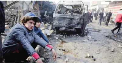  ?? —AP ?? IRAQ: Citizens inspect the scene after a car bomb explosion at a crowded outdoor market in the Iraqi capital’s eastern district of Sadr City, Iraq, yesterday.