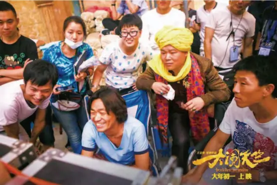  ??  ?? Working as a director for the first time, Wang watches the monitor with his production staff on location for Buddies inindia. courtesy of the film production team