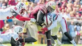  ?? MARK WALLHEISER/ASSOCIATED PRESS ?? FSU RB Jacquez Patrick absorbs a hit from NC State’s Shawn Boon, right, in Saturday’s ACC game in Tallahasse­e. Patrick says the Seminoles’ 0-2 start won’t define their season.