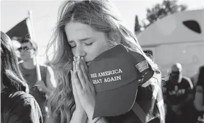  ?? PAULA BRONSTEIN/AP ?? Liza Durasenko, 16, from Oregon City, Oregon, prays during a rally in support of President Donald Trump, Aug. 29, in Clackamas, Oregon.