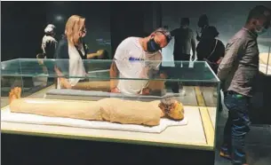  ?? XINHUA ?? Visitors look at exhibits in the Royal Mummies Hall at Cairo’s new National Museum of Egyptian Civilizati­on, which opened to the public on Sunday.