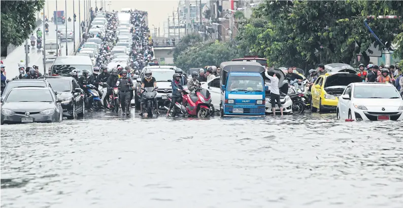  ?? PatiPat Janthong ?? Motorists stop their vehicles after driving down the Ratchada-Lat Phrao flyover and confrontin­g an impassable section of Ratchadaph­isek Road yesterday morning. Persistent downpours during the previous night brought heavy floods that paralysed many...