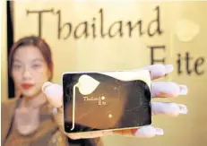  ?? APICHART JINAKUL ?? A woman presents the Thailand Elite Card, which allows for long-term visas and enables discounts on a variety of services to wealthy foreigners.