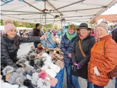  ??  ?? Den ersten Glühwein der Saison schenkten Jürgen Langhammer und Doris Leier an der Sektbar aus – die Besucher freute es sichtlich und orderten fleißig das heiße Getränk. Mützen waren der Renner: Am Stand von Alketa Kllokoqi aus Kempten probierte Johanna...